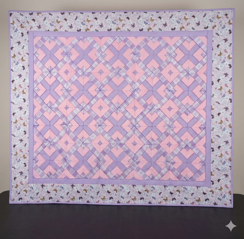 Geometric pattern quilt in soft pink and lilac tones with butterfly border